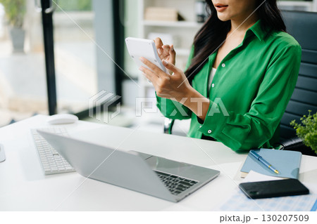 Women counting coins on calculator taking from the piggy bank. hand holding pen working on calculator Women counting coins on calculator taking from the piggy bank. hand holding pen working on calculator 130207509