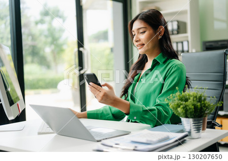 Young businesswoman working with working notepad, tablet and laptop documents talking on the smartphone, tablet 130207650