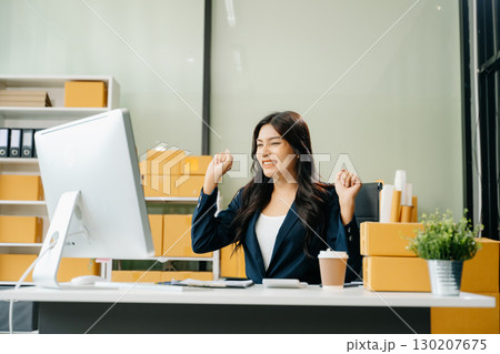 Young business owner woman prepare parcel box and standing check online orders for deliver to customer 130207675