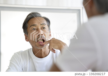 鏡を見て歯茎を気にする60代の男性 鏡を見て歯茎を気にする60代の男性 130208217