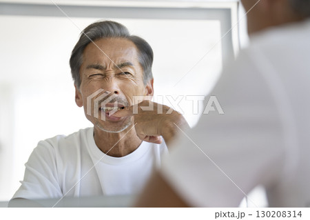 鏡を見て歯茎を気にするシニア男性 鏡を見て歯茎を気にするシニア男性 130208314