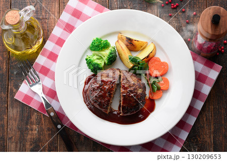 デミグラスソースのハンバーグステーキと彩り野菜　家庭的で温かみのある洋食シーン 130209653