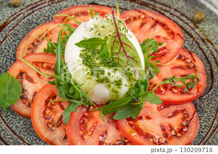 Fresh caprese salad with mozzarella, sliced tomatoes, arugula, and pesto sauce 130209718