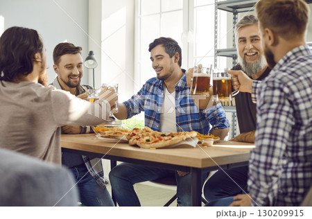Smiling bearded male friends with beer and pizza having fun sitting at home. 130209915