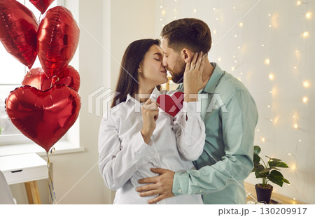 Portrait of young brunette man and woman hugging and kissing at home. Couple in love Portrait of young brunette man and woman hugging and kissing at home. Couple in love 130209917
