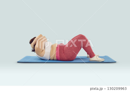 Young overweight woman doing crunches or sit ups on yoga mat during fitness workout Young overweight woman doing crunches or sit ups on yoga mat during fitness workout 130209963