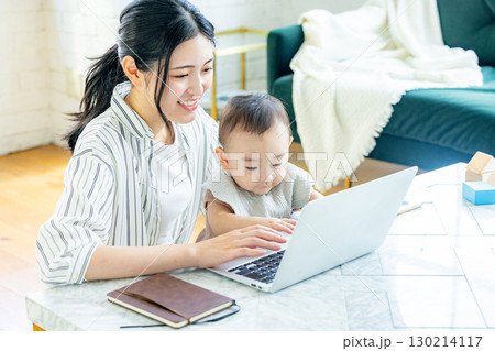 赤ちゃんを見ながらパソコンを見る女性 130214117