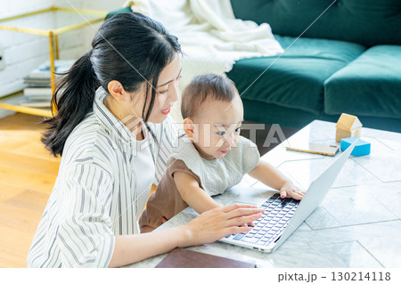 赤ちゃんを見ながらパソコンを見る女性 130214118
