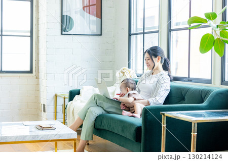 赤ちゃんを見ながらパソコンを見る女性 130214124