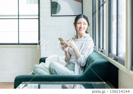 ソファーでくつろぐ女性 ソファーでくつろぐ女性 130214144