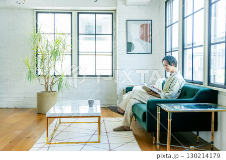 ソファに座って本を読む男性 130214179