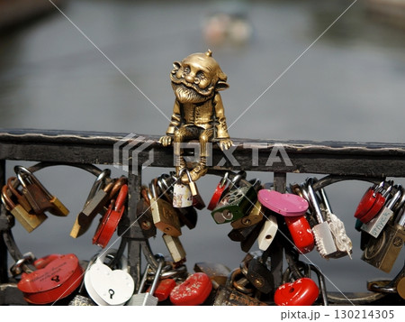 Love locks bridge and a small bronze statue of a bearded man. Love locks bridge and a small bronze statue of a bearded man. 130214305