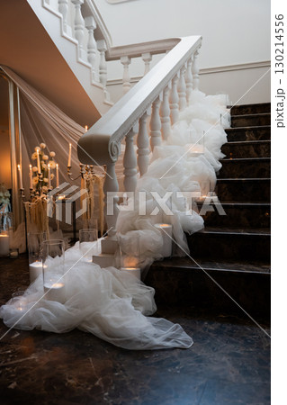 Elegant wedding reception staircase adorned with flowing white fabric Elegant wedding reception staircase adorned with flowing white fabric 130214556