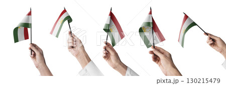 The Tajikistan flag in hand in different angles on a white background 130215479