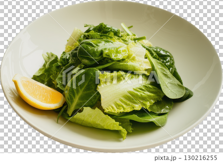 Fresh garden greens salad with a vibrant lemon wedge presented in a light colored bowl 130216255