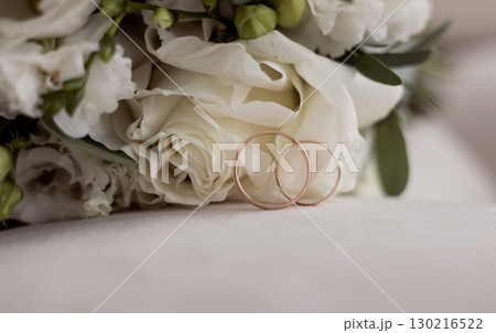 Elegant wedding rings near beautiful bouquet of flowers Elegant wedding rings near beautiful bouquet of flowers 130216522