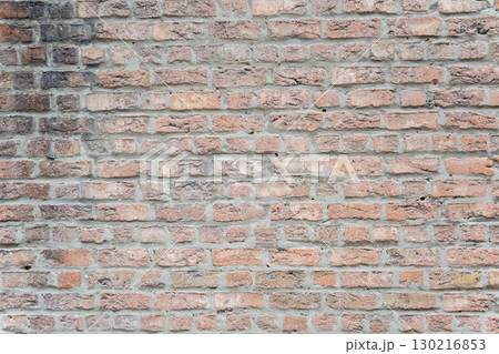 Brown structural stone wall of the ancient building consists of bricks. Nature structural background. 130216853
