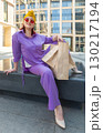 woman with craft shopping bags in the city. The concept of fashionable Consumerism and ecology.  130217194