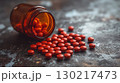 Red medication tablets scattered from amber bottle, healthcare concept 130217473