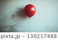 Red balloon floating against minimalist wall, conceptual solitude image 130217488