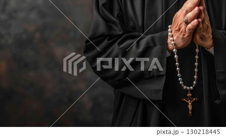 A closeup image captures a priest holding rosary beads, symbolizing faith and devotion in religious practices 130218445