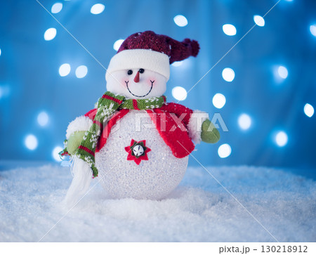 cute snowman toy on a blue background with 130218912