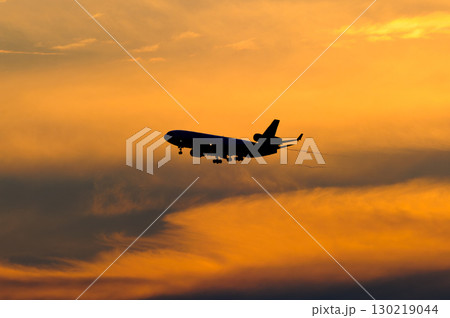 美しい夕日・空・雲を背景にした飛行機 130219044