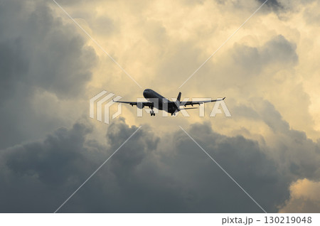 美しい夕日・空・雲を背景にした飛行機 130219048