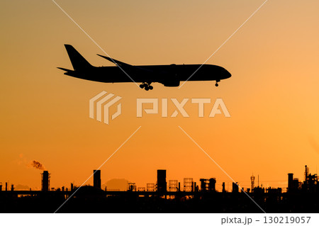 美しい夕日・空・雲を背景にした飛行機 130219057
