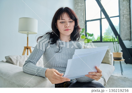 Web cam view of young woman with papers, online meeting, video call 130219256