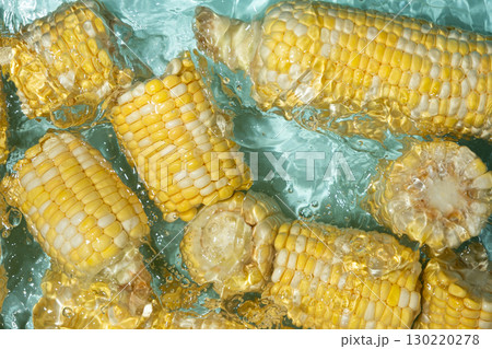 Fresh corn cobs splashing in water top view. 130220278