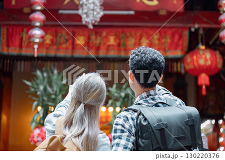 Couple exploring a vibrant cultural festival with lanterns and decorations 130220376