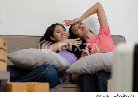 Loving LGBTQ couple relaxing on the couch with pillows after moving into their new home Loving LGBTQ couple relaxing on the couch with pillows after moving into their new home 130220378
