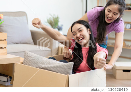 Joyful couple moving boxes, celebrating friendship and fun during relocation Joyful couple moving boxes, celebrating friendship and fun during relocation 130220419