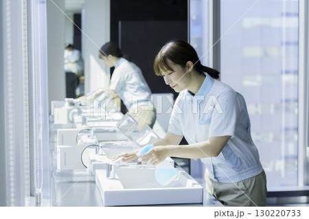 オフィスビルの洗面所の洗面台を拭く若い女性清掃員　撮影協力：学校法人電波学園 東京電子専門学校 130220733