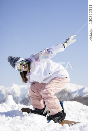 スノーボードを楽しむかわいい女性 スノーボードを楽しむかわいい女性 130223511