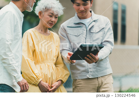 シニア夫婦にタブレットで説明をする業者 130224546