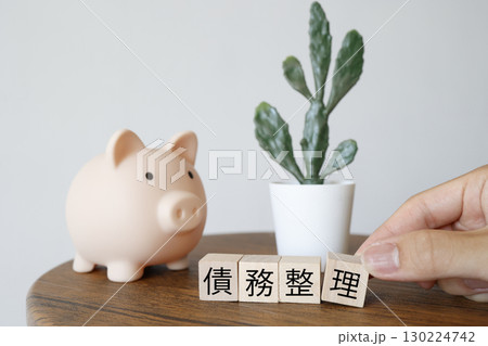 債務整理と貯金のイメージ、ブタの貯金箱と観葉植物。 130224742