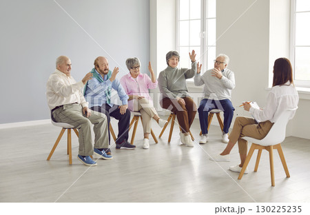 Group of senior people raising hands to pose questions to teacher, coach or psychologist Group of senior people raising hands to pose questions to teacher, coach or psychologist 130225235