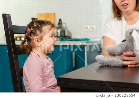Loving mother helping daughter learn through play in kitchen. Concept of positive parenting, preschool skills, and child psychology 130225654