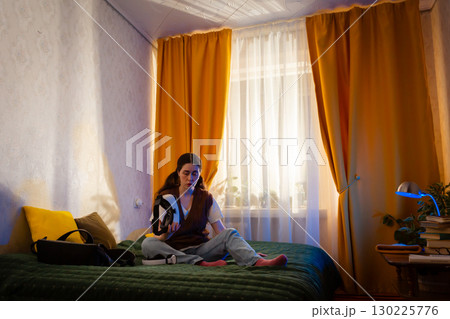 Tech savvy woman enjoys augmented simulation using VR headset in her bedroom. Innovative home entertainment concept. Low angle view, Wide shot 130225776