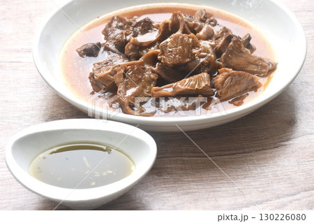 slice braised pork stew in herb brown soup dipping chili and sour sauce on plate 130226080