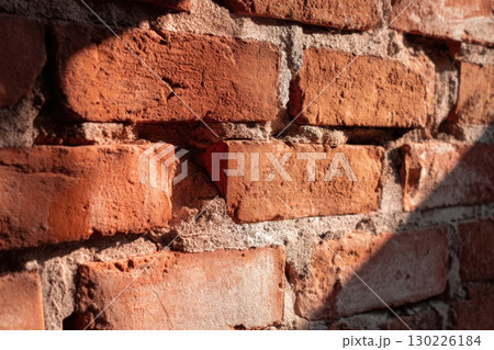 Rustic red brick wall with cracked texture and strong sunlight detail, perfect for vintage construction or architecture backgrounds with urban character Rustic red brick wall with cracked texture and strong sunlight detail, perfect for vintage construction or architecture backgrounds with urban character 130226184