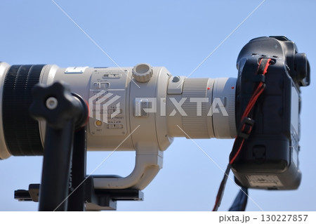 望遠レンズをつけた一眼レフカメラ 130227857