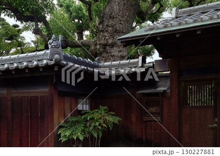 伝統的な日本建築の背景用素材。落ち着いた風合いの門と恵比寿像の飾り瓦。 130227881