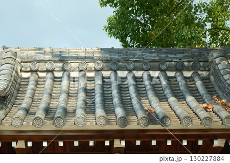 伝統的な日本建築の背景用素材。五瓜に唐花の紋が入った軒瓦。 伝統的な日本建築の背景用素材。五瓜に唐花の紋が入った軒瓦。 130227884