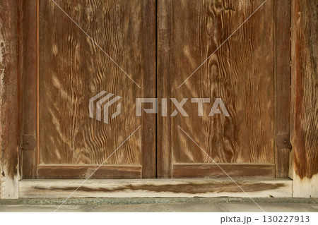 伝統的な日本建築の背景用素材。経年で色褪せた木製の門扉のクローズアップ。 伝統的な日本建築の背景用素材。経年で色褪せた木製の門扉のクローズアップ。 130227913