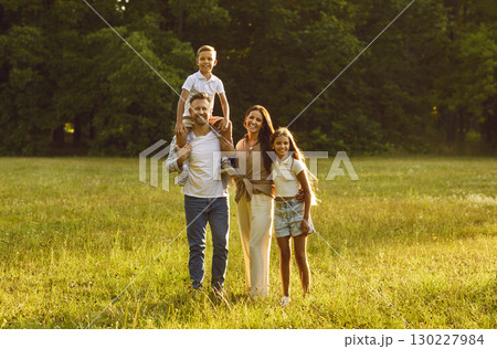Parents with two kids looking cheerful at camera in summer park. Happy family concept. 130227984