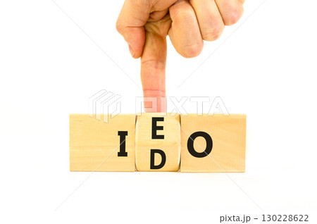 Initial exchange or DEX offering symbol. Concept words abbreviation IEO or IDO on wooden block. Beautiful white table white background. Business Initial exchange or DEX offering concept. Copy space. 130228622