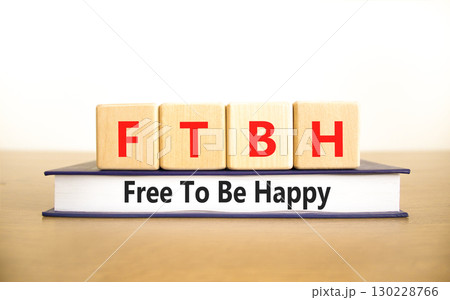 FTBH Free To Be Happy symbol. Concept word FTBH Free To Be Happy on beautiful wooden blocks and book. Beautiful white background. Business motivational FTBH Free To Be Happy concept. Copy space. 130228766